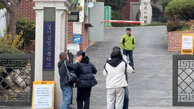 13일 서울 종로구 경기상업고 앞에서 수험생들과 학부모들이 인사를 나누고 있다. 문지수 기자