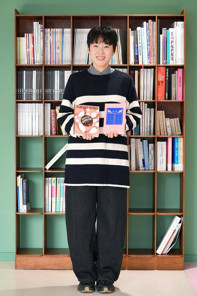 민지형 작가가 첫 소설 '나의 미친 페미니스트 여자친구'와 그의 출판사가 처음 펴낸 책 '한국에 남자가 너무 많아서'를 양손에 들고 서 있다. 임지훈 인턴기자