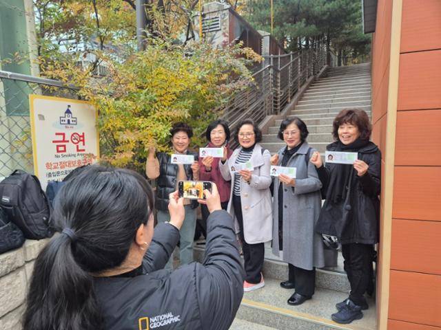 40세 이상 여성 만학도들을 가르치는 일성여중고의 수험생들이 13일 시험장인 서울 마포구 홍대부여고 옆에서 수험표를 들고 기념 촬영을 하고 있다. 김나연 기자