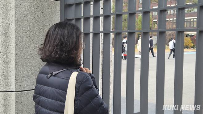 2026학년도 대학수학능력시험이 치러진 13일 휘문고 정문 앞에서 한 학부모가 교문 너머로 들어가는 학생들을 지켜보고 있다. 황인성 기자 &nbsp;