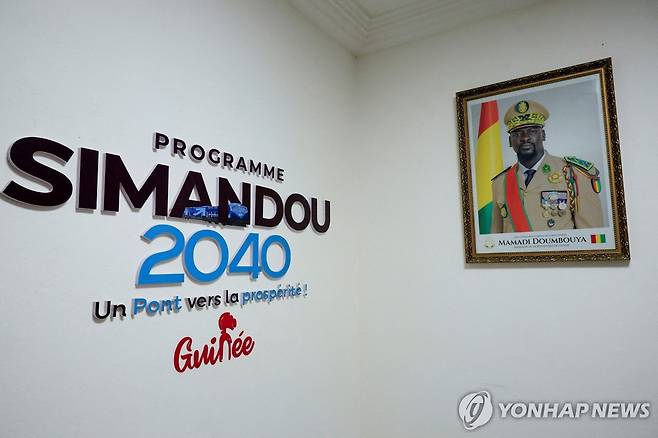 시만두 철광산을 기반으로 한 기니의 경제발전 계획 '시만두 2040' 로고와 기니 군정수반 마마디 둠부야의 사진. [로이터=연합뉴스 자료사진]
