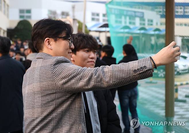 '수능 끝난 아들과' (대전=연합뉴스) 이주형 기자 = 2026학년도 대학수학능력시험이 치러진 13일 오후 대전 서구 서대전고에서 수능을 마친 한 수험생이 아버지와 함께 기념사진을 남기고 있다. 2025.11.13 coolee@yna.co.kr