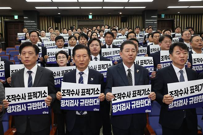 더불어민주당 정청래 대표와 김병기 원내대표가 13일 서울 여의도 국회에서 열린 의원총회에서 "정치검사 규탄한다!"라고 적힌 팻말을 들고 구호를 외치고 있다./연합뉴스