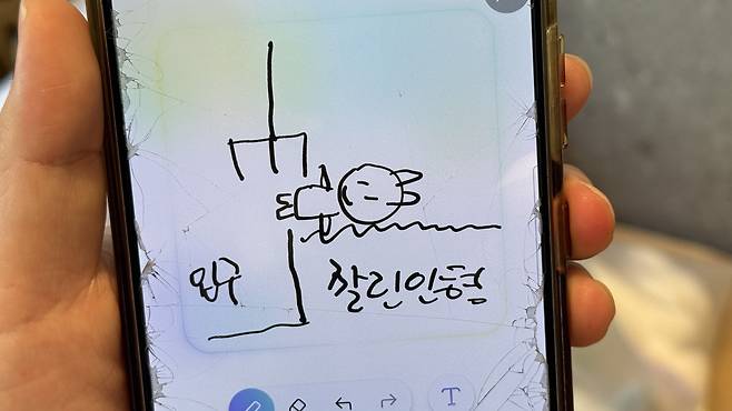 Kim draws to explain how to tap a plushie out near the exit. [WOO JI-WON]