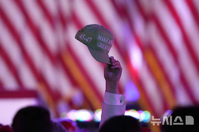 [웨스트팜비치=AP/뉴시스] 도널드 트럼프 미국 대통령과 강성 마가(MAGA) 진영이 이민 정책과 '엡스타인 이메일' 파문으로 분열 조짐을 보이고 있다. 사진은 지난해 대선 당시 트럼프 대통령 유세 현장에서 한 지지자가 '마가'(MAGA) 모자를 들어 올리는 모습. (사진=뉴시스DB) 2025.11.14.