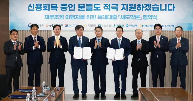 권대영(왼쪽 다섯 번째 금융위원회 부위원장과 이재연(〃 네 번째) 신용회복위원회 위원장을 비롯한 정부 및 은행권 인사들이 14일 서울 중구 신복위 본사에서 열린 '새도약론 협약식'에 참석해 박수를 치고 있다. 사진 제공=금융위