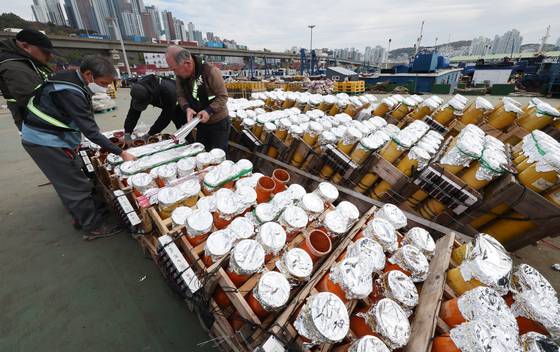 지난 13일 부산 남구 7부두에서 정박한 바지선에서 한화 직원들이 불꽃놀이 화약을 장착하는 등 준비가 한창이다. 이번 축제에는 바지선이 지난해보다 5척 많은 13척 동원되며 9만발의 불꽃이 부산 광안리해수욕장 밤 하늘을 수놓을 예정이다. 송봉근 객원기자