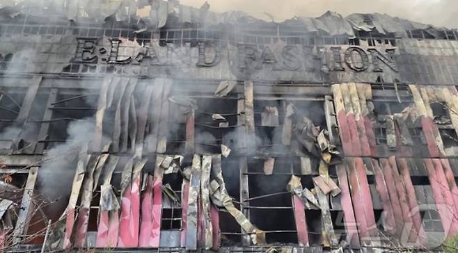 15일 충남 천안 동남구 이랜드패션 물류센터에서 발생한 화재로 건물 외장재가 떨어지고 외벽이 검게 탔다. 소방 당국은 9시간 30분 만에 큰불을 잡았지만 대응 2단계를 유지한 채 화재를 계속 진압 중이다. [뉴스1]