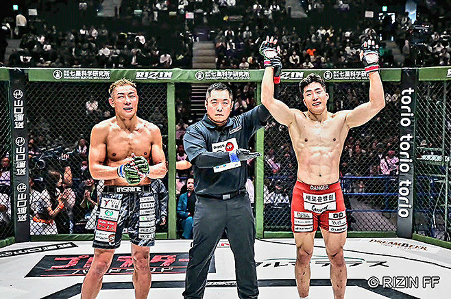 Road to UFC 시즌1~3 기원빈이 2025년 11월 일본 효고현 고베 지라이온 아레나 관중 1만420명이 보는 가운데 라이진 랜드마크 12 제3경기 승리 선언을 받고 있다. 왼쪽은 패배를 인정하는 제15대 Shooto 라이트급 챔피언 데바나 슈타로. 사진=RIZIN FF