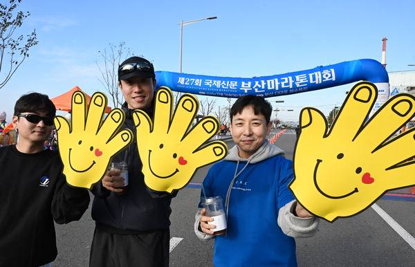 참가자들을 응원하기 위해 찾은 이들이 대형 손 응원 도구를 들어 보이고 있다.