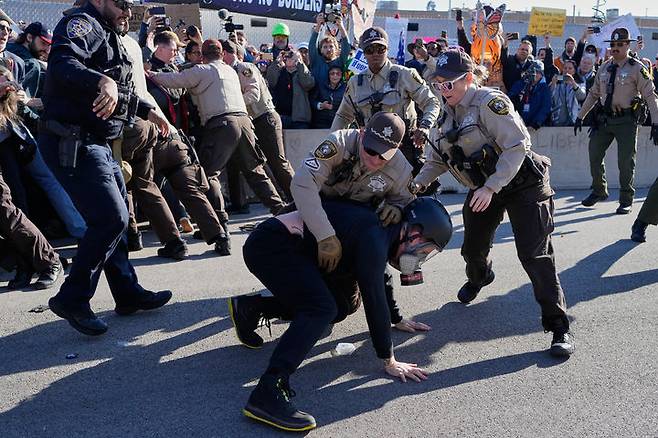 [브로드뷰=AP/뉴시스]  미 일리노이주 시카고 교외 브로드뷰에 있는 이민세관단속국(ICE) 시설 밖에서 11월 14일 쿡 카운티 보안관들이 한 시위 참가자를 체포하고 있다.  ICE는 그 동안 소문이 무성하던 노스 캐롤라이나 샬럿 시에 대한 단속도 이 날 시작해 이민자 비율이 높은 이 도시에서 시민권자까지 체포하고 있다.  2025.11.16.