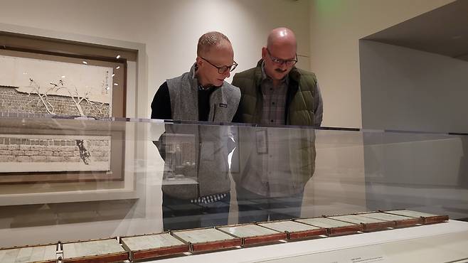 美워싱턴서 열린 '이건희 컬렉션' 특별전 (워싱턴=연합뉴스) 김동현 특파원 = 15일(현지시간) 미국 워싱턴DC의 국립아시아예술박물관에서 열린 '한국의 보물: 모으고, 아끼고, 나누다' 특별전에서 게리 바쇼(50)씨와 조시 매키(42)씨가 '신정왕후 가상존호 옥책'을 보고 있다. 2025.11.15