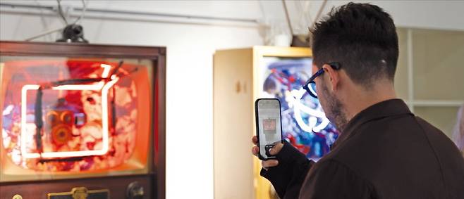서울 안국동 아트링크갤러리를 찾은 세바스티안 산체스 전 크리스티 디지털아트 세일즈 매니저가 백남준의 작품을 촬영하고 있다.  /예술경영지원센터 제공