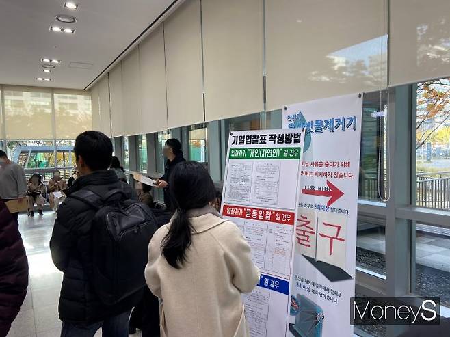 최저 매각가격보다 3억원 이상 높은 가격에 경매가 이뤄진 e편한세상송파파크센트럴의 낙찰가율은 103.0%다. 사진은 기일 입찰표 작성 방법을 보고 있는 한 시민. /사진=최성원 기자