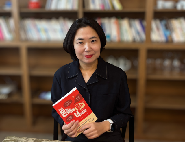 이미진 재무설계사가 최근 출간한 ‘오늘도 돈 때문에 힘든 너에게’를 들고 포즈를 취하고 있다. 사진 제공=느낌이있는책