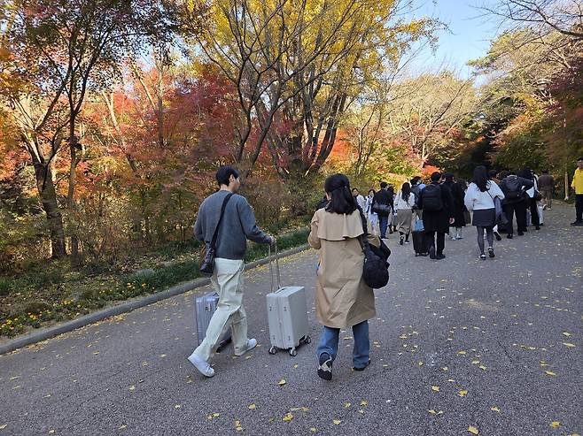 여성 참가자의 가방을 들어주며 수덕사로 향하는 남성 참가자 [촬영 정지수 수습기자]