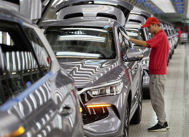 중국 허난성 정저우에 위치한 BYD 공장의 생산 라인에서 한 직원이 친환경 차 '송 프로' 차량을 검사하고 있다.  신화연합뉴스