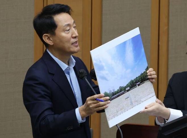 오세훈 서울시장이 18일 서울 중구 서울시의회에서 열린 제333회 정례회 시정질문에 참석, 세운4구역 재개발과 관련된 자료를 들고 질의에 답하고 있다. 연합뉴스