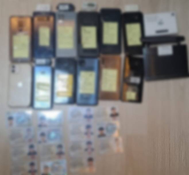 통장 모집책으로부터 압수한 타인 명의의 휴대전화와 신분증. /부산경찰청