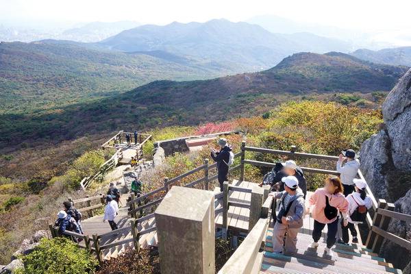 24번째 국립공원으로 지정된 금정산 정상에서 바라본 전경. 국립공원 지정을 축하하고 가을 정취를 만끽하려는 많은 등산객이 고당봉을 오르고 있다. 멀리 금련산 황령산 백양산 엄광산 승학산 등이 펼쳐져 있으며, 오른쪽에 강원도 태백 황지에서부터 1300리를 쉼 없이 달려 온 낙동강 하구의 모습도 보인다.
