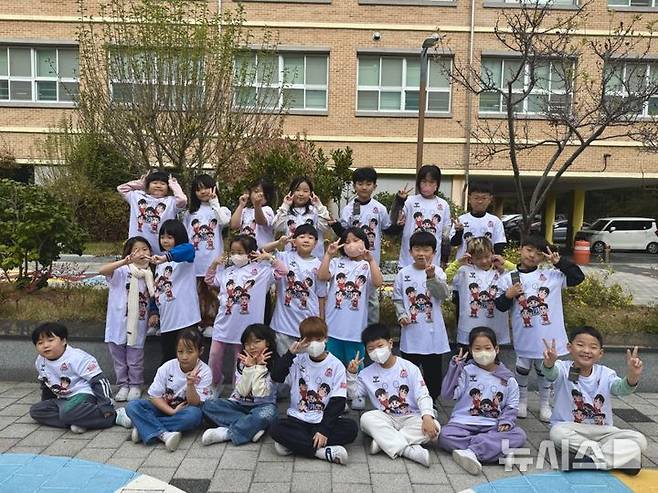 [서울=뉴시스]OK저축은행 응원티셔츠를 받은 부산 송정초 1학년 학생들. (사진=OK저축은행 배구단 제공)