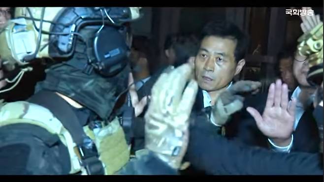 지난해 '12·3 내란의 밤' 당시 계엄군의 국회 진입을 막아선 김민기 국회 사무총장 눈빛이 형형하다. 사진=국회방송 갈무리