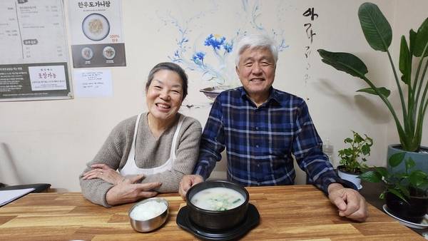 아라정원을 운영하는 문강홍(오른쪽), 이수경화 부부가 곰탕을 앞에 놓고 환한 미소를 짓고 있다. /이원재 기자