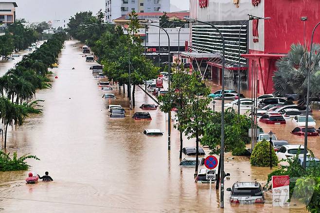 20일(현지시간) 베트남 카인호아성 나트랑에서 사람들이 침수된 차량 근처를 헤치고 있다. 2025.11.20. ⓒ AFP=뉴스1 ⓒ News1 이정환 기자