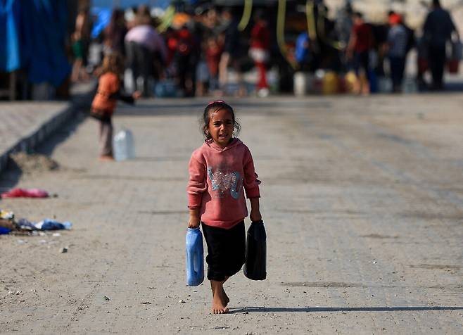 19일(현지시각) 팔레스타인 가자지구 가자시티에서 맨발의 팔레스타인 어린이가 물통을 들고 가고 있다. 로이터 연합뉴스