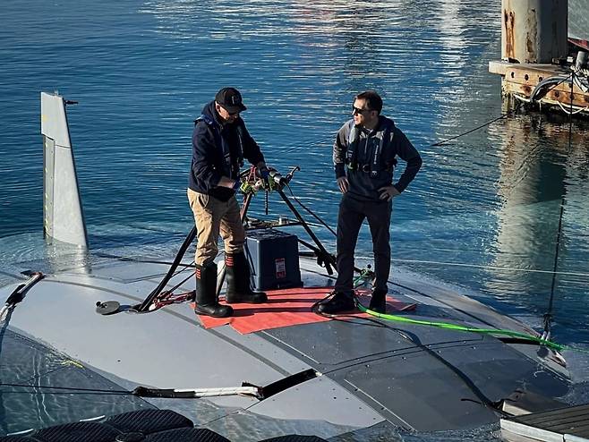 DARPA 프로그램 매니저인 카일 워너 박사(오른쪽)가 노스롭그루먼 팀의 한 구성원과 만타레이 기체 위에서 대화를 나누고 있다.