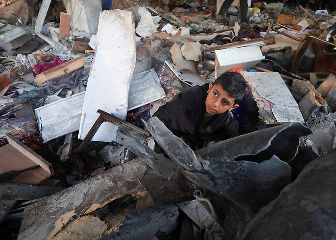 20일(현지시간) 가자시티에서 팔레스타인 어린이가 이스라엘군이 전날 공습한 지역을 둘러보고 있다. 로이터연합뉴스