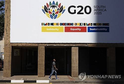 남아공 요하네스버그 시내 G20 광고판 지난 13일(현지시간) 남아프리카공화국 요하네스버그 시내의 G20 정상회의를 알리는 간판 아래 한 보행자가 지나가고 있다. 2025.11.20 [EPA=연합뉴스]
