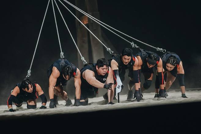 /넷플릭스지난 18일 공개된 넷플릭스 ‘피지컬: 아시아’ 결승전에서 쇳덩이를 끌고 있는 한국팀(왼쪽부터 장은실, 윤성빈, 김민재, 김동현, 아모띠, 최승연)./넷플릭스