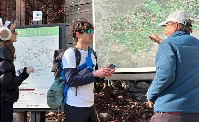 19일 오후1시쯤 영국인 관광객 댄 헤일펀(25)씨가 백운대탐방지원센터 인근에서 한국인 중년 남성에게 북한산 안에 있는 절이 어디에 있는지 묻고 있다. /김수아 기자