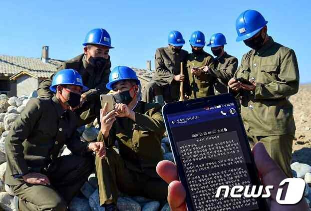 (평양 노동신문=뉴스1) =   수해 복구에 투입된 인민군들이 휴대전화로 위문편지를 읽고 있는 모습. [국내에서만 사용가능. 재배포 금지. DB 금지. For Use Only in the Republic of Korea. Redistribution Prohibited] rodongphoto@news1.kr