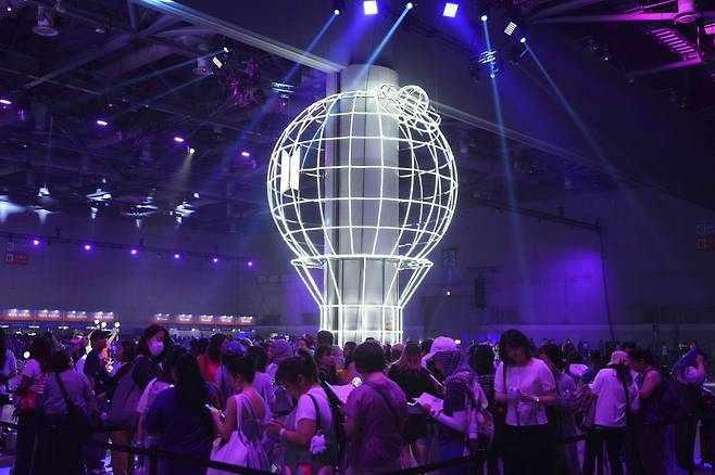 K-pop 그룹 BTS의 팬들이 고양시에서 열린 BTS 데뷔 기념 연례 행사인 ‘2025 BTS 페스타’ 기간 동안 아미 밤(ARMY Bomb) 근처에서 사진을 찍기 위해 기다리고 있다. AP/뉴시스