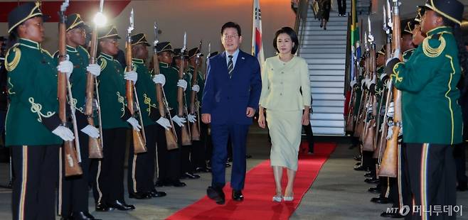 [요하네스버그=뉴시스] 최동준 기자 = G20 정상회의에 참석하는 이재명 대통령과 김혜경 여사가 21일(현지 시간) 남아프리카공화국 요하네스버그 O.R. 탐보 국제공항에 도착해 공군1호기에서 내려 이동하고 있다. 2025.11.22. photocdj@newsis.com /사진=
