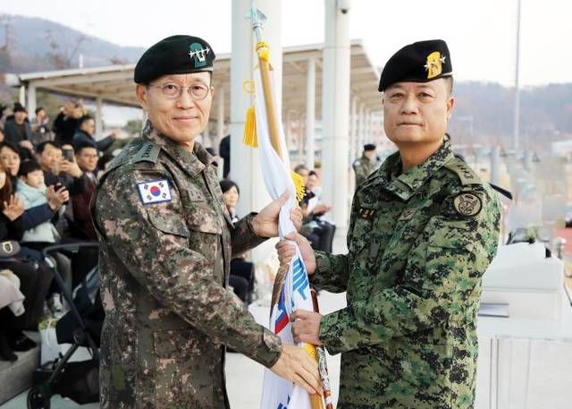 지난 20일 육군특수전사령부 연병장에서 열린 제34대 특수전사령관 취임식에서 김규하(왼쪽) 육군참모총장이 박성제 사령관에게 부대기를 이양하고 있다. 부대 제공