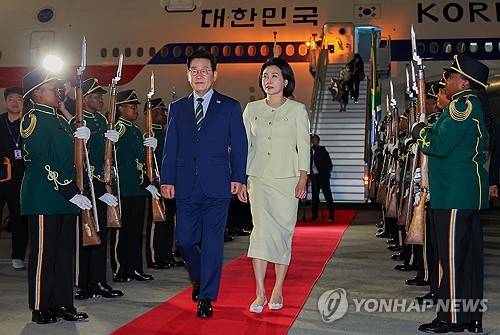 주요 20개국(G20) 정상회의에 참석하는 이재명 대통령이 김혜경 여사와 함께 21일(현지시간) 남아프리카공화국 요하네스버그 OR탐보국제공항에 도착한 뒤 공군 1호기에서 내려 이동하고 있는 모습. [사진 제공] 연합뉴스