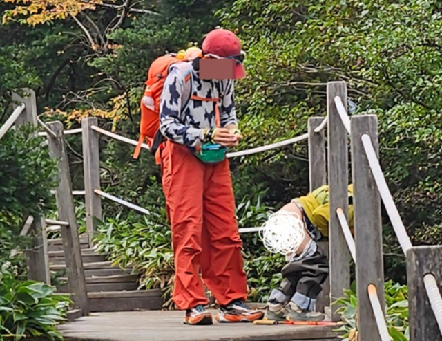 중국인 가족 중 한 명이 한라산 등산로에서 대낮에 대변을 보고 있다. [한라산국립공원 홈페이지 캡처]
