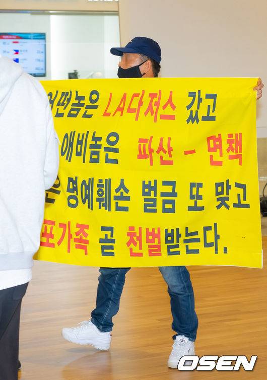 [OSEN=인천공항, 민경훈 기자] 미국프로야구 메이저리그(MLB)&nbsp;LA 다저스의 김혜성이 6일 오후 인천국제공항을 통해 귀국했다.김혜성은 메이저리그 진출 첫 해 우승반지를 거머쥐는 영광을 누렸다. 한국인 메이저리거 야수로는 역대 최초로 월드시리즈 우승반지를 차지한 김혜성은 올해 71경기 출전, 타율 0.280(161타수 45안타), 3홈런 17타점 19득점, 13도루(1실패), 출루율 0.314 장타율 0.385, OPS 0.699의 기록으로 정규시즌을 마무리했다.김혜성이 입국장 앞에서 인터뷰를 할때 한 남성이 비난 현수막을 펼치고 있다. 2025.11.06 /rumi@osen.co.kr