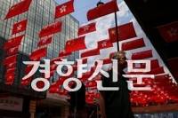 지난달 1일 한 남성이 중국 국경절 76주년을 맞아 한 쇼핑몰에 걸려있는 오성홍기와 홍콩기 아래로 걸어가고 있다. 로이터연합뉴스