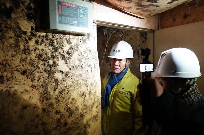 Lee Seung-ro, mayor of Seongbuk-gu, looks inside a demolished brothel in Miari Texas on Monday. (Seongbuk District Office)