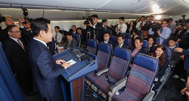 President Lee Jae Myung, second from left, speak during a press conference with domestic reporters aboard the Korean Air Force One en route to Ankara, Turkey, on Nov. 23. [JOINT PRESS CORPS]