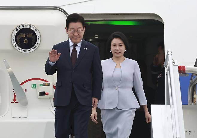 President Lee Jae Myung and first lady Kim Hea Kyung wave as they depart the Korean Air Force One upon arrival at Ankara Esenboga Airport in Ankara, Turkey, on Nov. 24. [YONHAP]