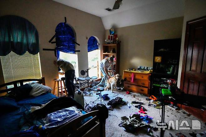 [텍사스주=AP/뉴시스] 24일(현지 시간) 미국 텍사스주 메모리얼 노스웨스트 지역에서 주민들이 토네이도로 인해 파손된 주택 창문에 방수포를 설치하고 있다. 2025.11.25.