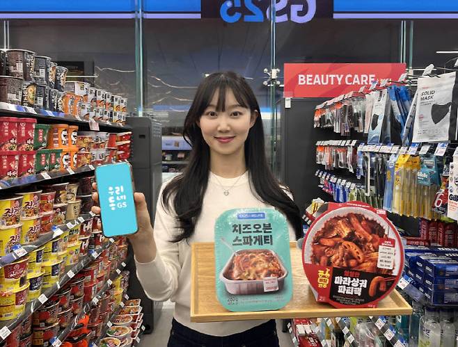 모델이 GS25 매장에서 마라샹궈파티팩, 치즈오븐스파게티를 소개하고 있다. (사진=GS리테일)