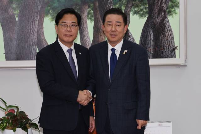 김병기 더불어민주당 원내대표와 송언석 국민의힘 원내대표(왼쪽)가 25일 서울 여의도 국회에서 대장동 사건 항소포기 여야 국정조사 등 쟁점에 대해 협상하기에 앞서 악수하고 있다. [연합뉴스]