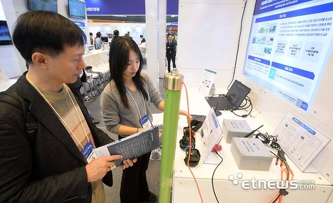 지난해 열린 '2024 AIoT 국제전시회'의 한국전자기술연구원 부스에서 관람객이 산림재해 대응 디지털 트윈 시스템에 대한 설명을 듣고 있다.