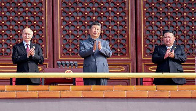 김정은(오른쪽부터) 북한 국무위원장, 시진핑 중국 국가주석, 블라디미르 푸틴 러시아 대통령이 10월 3일 중국 베이징에서 열린 '중국 인민 항일 전쟁 및 세계 반파시스트 전쟁 승리(전승절) 80주년' 열병식에 참관하고자 톈안먼 망루에 서 손뼉을 치며 보고 있다. 베이징=EPA 연합뉴스